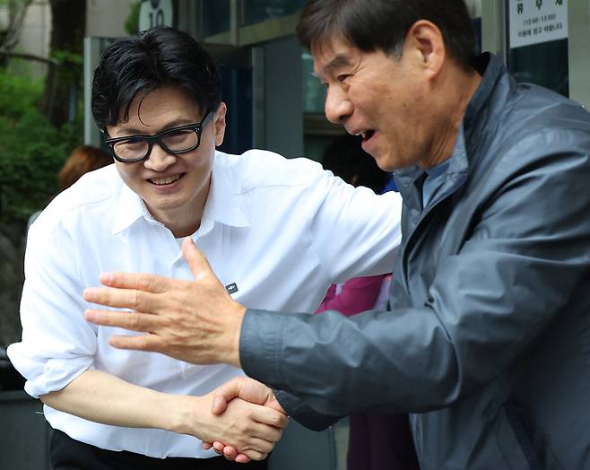 한동훈 전 국민의힘 대표가 지난 14일 오후 부산 북구 만덕2동 행정복지센터를 찾아 전입신고를 마친 뒤 주민들과 사진을 찍고 있다. 한 전 대표는 이곳으로 전입신고를 하며 전재수 의원의 부산시장 출마로 보궐선거 진행될 예정인 부산 북구갑 출마를 공식화했다. [연합뉴스]