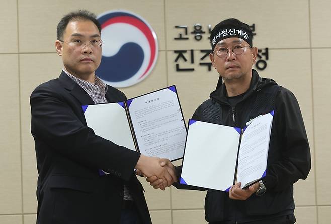 민주노총 공공운수노조 화물연대본부(화물연대)와 BGF로지스가 30일 오전 경남 진주시 고용노동부 진주지청에서 단체합의서 조인식을 했다. 사진은 이민재 BGF로지스 대표이사(왼쪽)와 김동국 화물연대 위원장이 기념 촬영을 하는 모습. [연합뉴스]