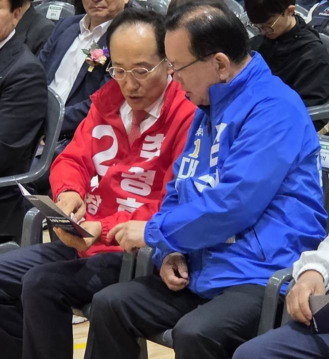 노동절인 1일 오전 추경호 국민의힘 대구시장 후보와 김부겸 더불어민주당 후보가 자리에 앉아 기념대회 안내책자를 나란히 보고 있다. 뉴스1