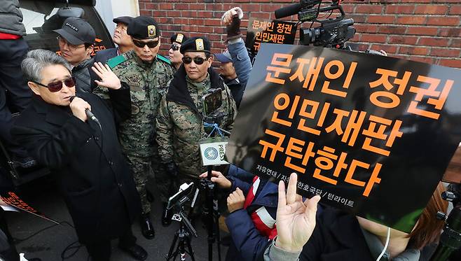 사자명예훼손 혐의로 전두환씨가 기소돼 재판이 예정되던 2019년 3월11일 오전 서울 서대문구 연희동 전 전 대통령 자택 앞에서 지만원씨(왼쪽)를 비롯한 지지자들이 피켓을 들고 구호를 외치고 있다. 20년 동안 지속적으로 5·18을 왜곡한 지만원 씨는 5·18 관련 북한 침투설 등 허위 사실을 퍼뜨린 혐의로 징역 2년이 확정돼 교도소에 수감됐다가 출소한 바 있다. 연합뉴스