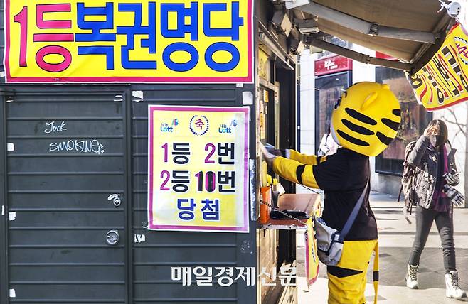 인형 탈을쓴 아르바이트생이 로또 복원을 구매하고 있다. [이충우 기자]