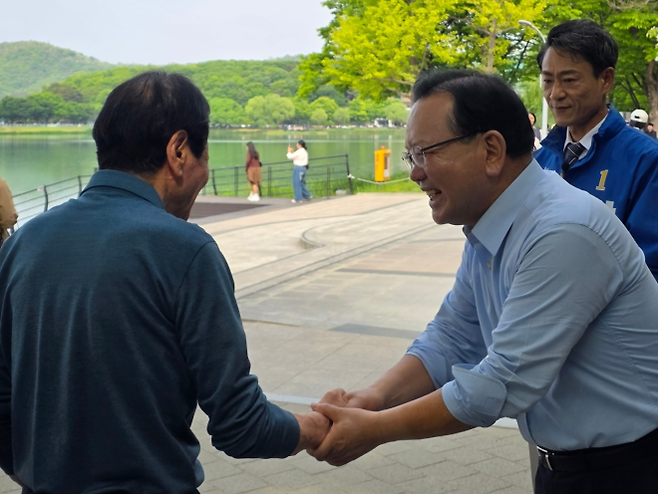 더불어민주당 대구시장 후보인 김부겸 전 국무총리가 2일 대구 수성구 두산동에 있는 수성못에서 시민과 악수를 하고 있다. 2026. 5. 2. 대구 민경석 기자