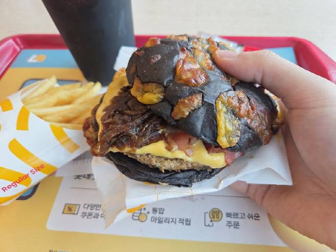 검은 번 위에 치즈를 구워 붙인 ‘번트치즈번’이 눈에 띄는 롯데리아 ‘번트비프버거’ (사진=한전진 기자)
