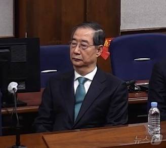 한덕수 전 국무총리가 21일 서울 서초구 서울중앙지방법원에서 열린 내란 우두머리 방조, 내란 중요임무 종사 혐의 사건 1심 선고공판에 출석해 자리에 앉아있다. (서울중앙지방법원 제공 영상 캡쳐. 재판매 및 DB 금지) 2026.1.21 ⓒ 뉴스1