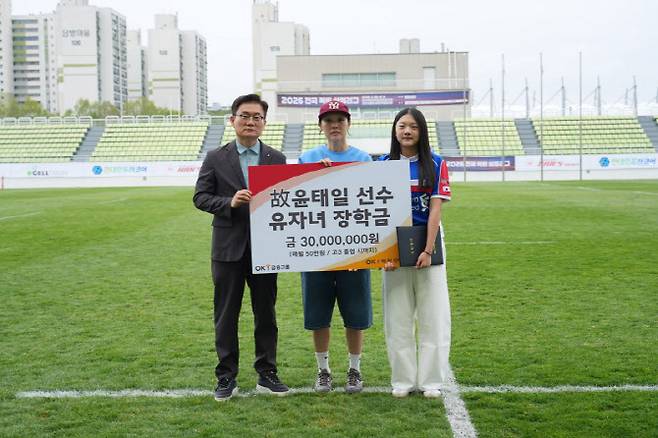 OK저축은행 럭비단 권철근 단장이 고 윤태일 선수 유족에게 생활비 장학금 3000만원을 전달하고 있다. 사진=OK저축은행