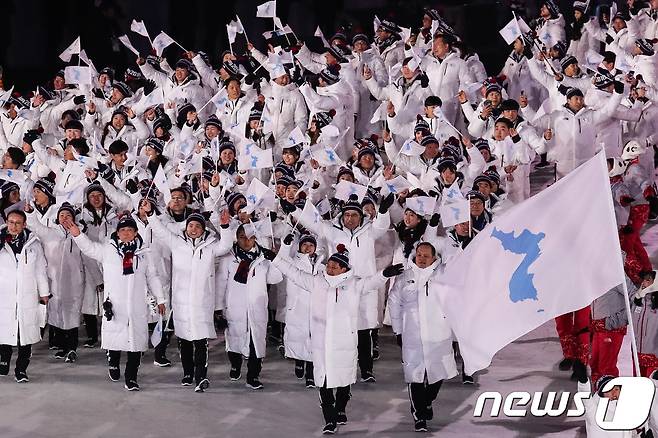 9일 강원도 평창올림픽스타디움에서 열린 평창동계올림픽 개회식에서 남북한 선수단이 한반도기를 흔들며 입장하고 있다. 기수는 대한민국 봅슬레이 원윤종 선수와 북한여자아이스하키 황충금 선수. 남북한 선수단의 올림픽 공동입장은 2006년 토리노 동계올림픽 이후 13년 만이다.  2018.2.9 ⓒ 뉴스1 유승관 기자