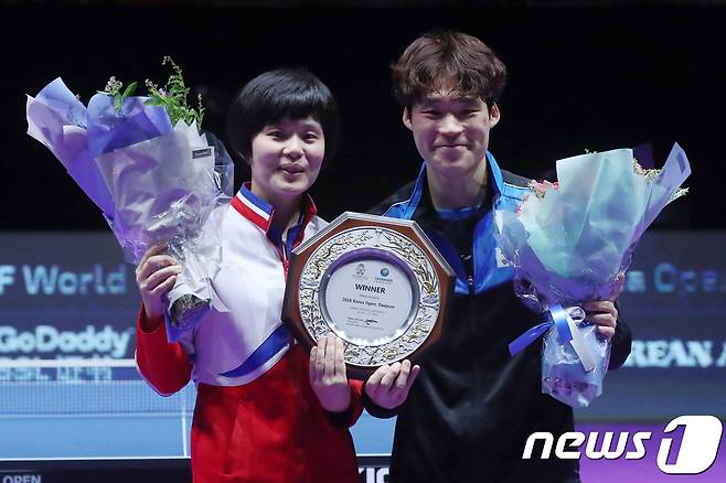 21일 대전 중구 충무체육관에서 열린 '2018 코리아오픈 국제탁구대회' 혼합복식 결승에 출전한 남북단일팀 한국 장우진·북한 차효심이 중국대표팀과의 경기에서 세트스코어 3대1로 승리를 거둔 뒤 시상식에 참석해 트로피와 꽃다발을 들고 밝게 웃고 있다. 2018.7.21 ⓒ 뉴스1 민경석 기자
