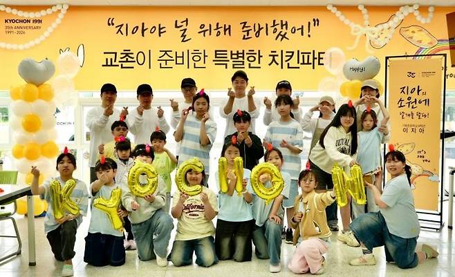 지난달 30일 경북 포항시 기북초등학교에서 열린 어린이날 행사에서 교촌에프앤비 임직원들이 학생들을 위한 치킨파티를 진행하고 기념사진 촬영을 하고 있다. 교촌에프앤비 제공