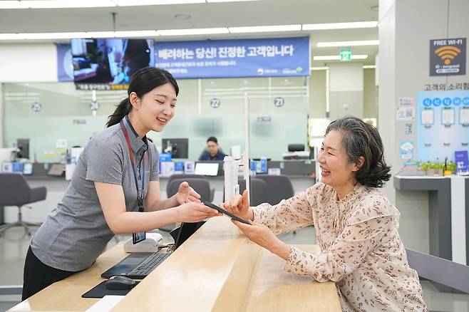삼성전자서비스 직원이 시니어 고객에게 스마트폰 사용법을 설명하고 있다. /삼성전자서비스