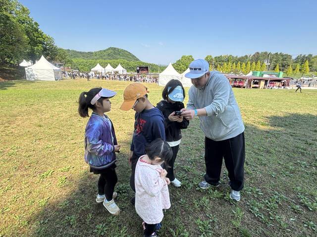 연천 구석기 축제에 방문한 노승환씨(40)가 네 남매를 데리고 잔디밭 위에서 ‘연천 구석기 트레저’를 즐기고 있다. 서다희기자