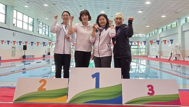 (사)한국농아인협회 칠곡군지회 소속 농아 선수들이 수영에서 금, 은메달을 딴 후 관계자들과 기념사진을 찍고 있다. (사)한국농아인협회 칠곡군지회 제공