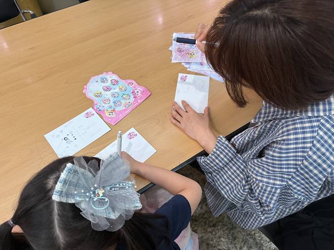 6살 딸과 서울중앙우체국을 찾은 박모(39)씨가 지난 4일 '캐치! 티니핑' 기념우표로 엽서를 꾸미고 있다. /현정민 기자