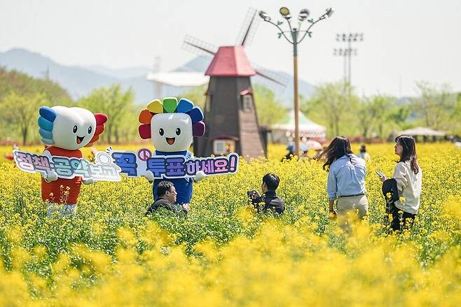 지난달 20일 경남도선거관리위원회가 창녕군 남지읍 낙동강 유채단지에서 제9회 전국동시지방선거 투표 참여를 독려하는 퍼포먼스를 하고 있다. 경남도선거관리위원회 제공