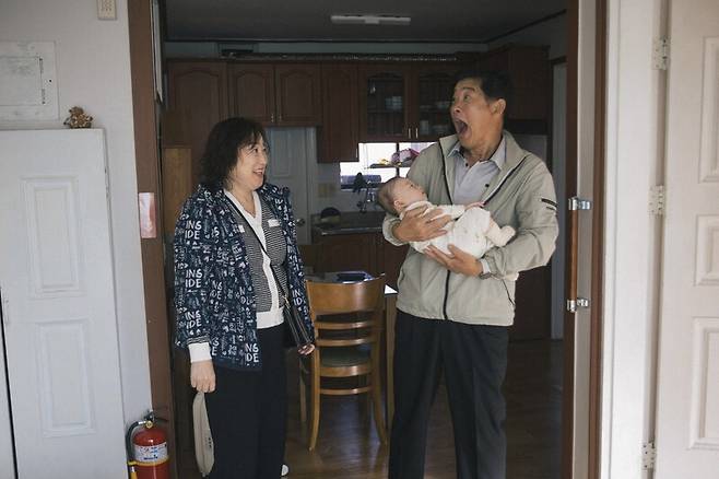 수어를 사용하는 필자의 농인 부모가 손주를 안고 얼굴 표정으로 대화하는 모습. 사진 다나카 겐
