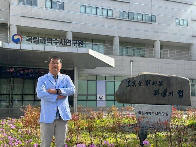 홍현기 국립과학수사연구원 법의검사과 심리연구사가 지난달 22일 강원 원주 국과수 본원 청사 앞에서 포즈를 취하고 있다. 그의 옆에 놓인 원훈석에는 '진실을 밝히는 과학의 힘'이라고 새겨져 있다. 원주=강지수 기자