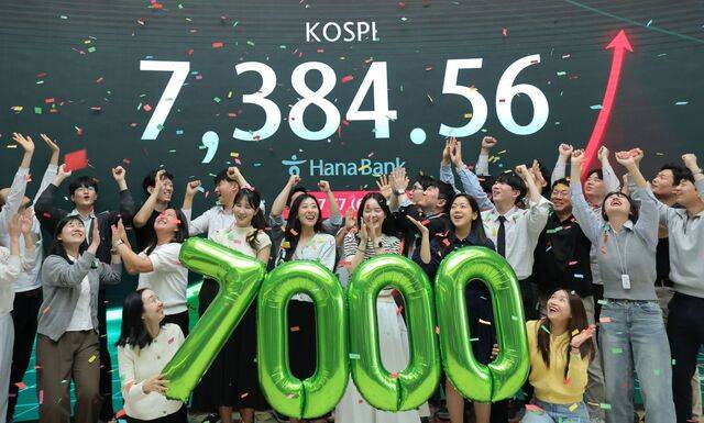 코스피가 7천을 돌파한 6일 서울 중구 하나은행 본점 딜링룸에서 직원들이 축하 세리머니를 하고 있다. 이한형 기자