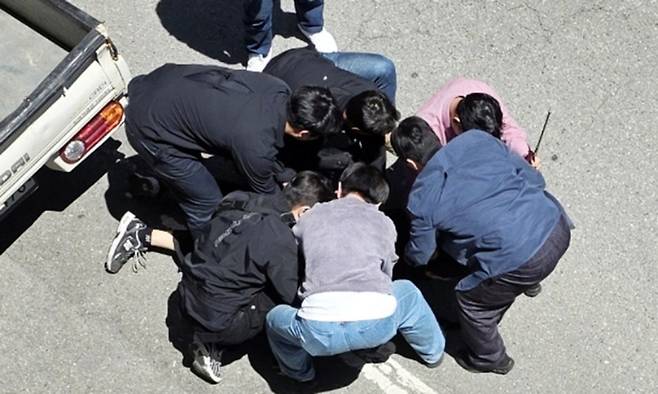5일 광주 광산구 월계동 한 도로에서 살인 혐의 등을 받는 20대 피의자 장모 씨를 경찰이 긴급 체포하고 있다. 장씨는 이날 오전 광산구 월계동 한 대학교 인근 도로에서 흉기를 찔러 여고생을 살해하고 또래 남고생에게도 흉기를 휘두른 혐의를 받고 있다. 연합뉴스