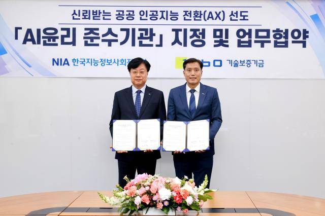 박주선 기보 전무이사와 김형철 한국지능정보사회진흥원장(왼쪽)이 지난 6일 대구 동구에 위치한 NIA 본원에서업무협약 후 기념촬영을 하고 있다. [사진=기술보증기금]
