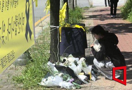 7일 오전 광주 광산구 월계동 사건 현장에 한 시민이 국화꽃을 내려놓으며 희생된 여고생을 추모하고 있다. 송보현 기자