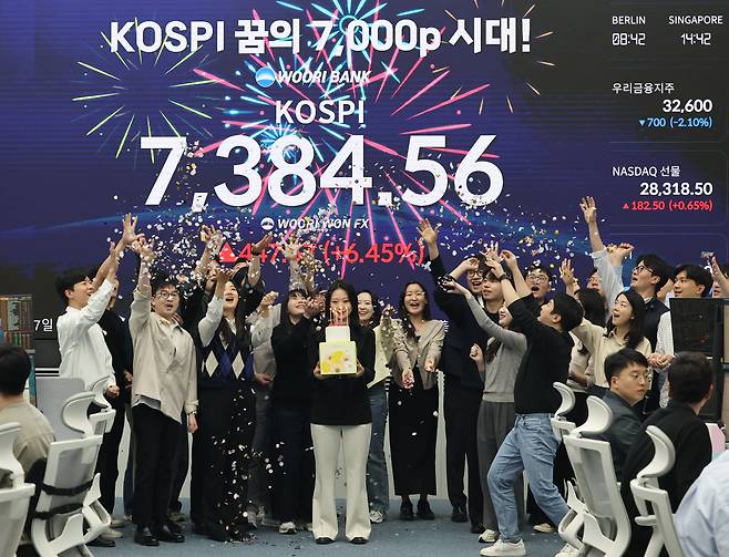 코스피가 사상 처음으로 종가 기준 7,000선을 돌파하며 장을 마친 6일 서울 중구 우리은행 본점 딜링룸에서 직원들이 축하 세리머니를 하고 있다. /연합뉴스