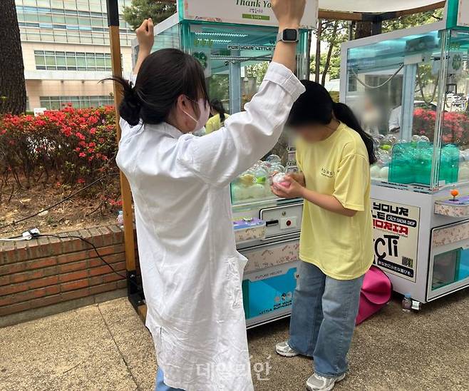 서울성모병원 의료진이 7일 병원 야외공원에서 열린 ‘봄, 우리답게 고맙습니다’ 캠페인에서 인형뽑기를 하고 있다. 인형을 뽑고 좋아하는 모습. ⓒ데일리안 김효경 기자