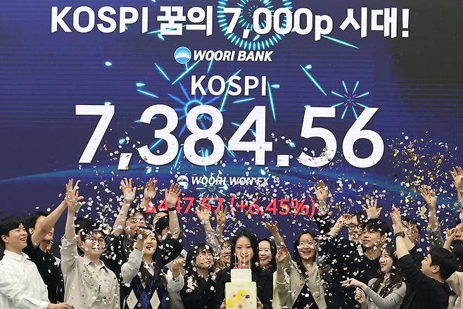 코스피가 사상 처음으로 종가 기준 7,000선을 돌파하며 장을 마친 6일 서울 중구 우리은행 본점 딜링룸에서 직원들이 축하 세리머니를 하고 있다. 연합뉴스