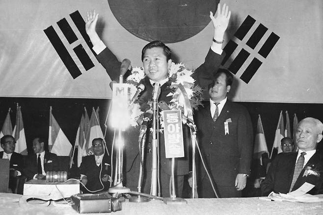 1970년 9월 신민당 대통령 후보 지명대회에서 김대중 후보가 김영삼 의원과 2차 투표까지 가는 접전 끝에 승리한 뒤 후보 수락 연설에 앞서 환호하는 대의원들에게 손들어 답하고 있다. 한국일보 자료사진