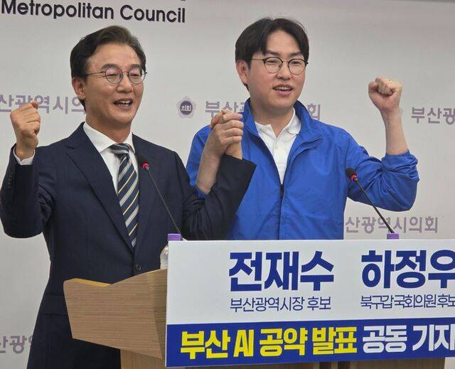 더불어민주당 전재수 부산시장 후보와 하정우 부산 북갑 국회의원 보궐선거 후보가 6일 부산 연제구 부산시의회에서 인공지능(AI) 공약 발표 공동 기자회견을 마친 뒤 기념촬영을 하고 있다.  연합뉴스