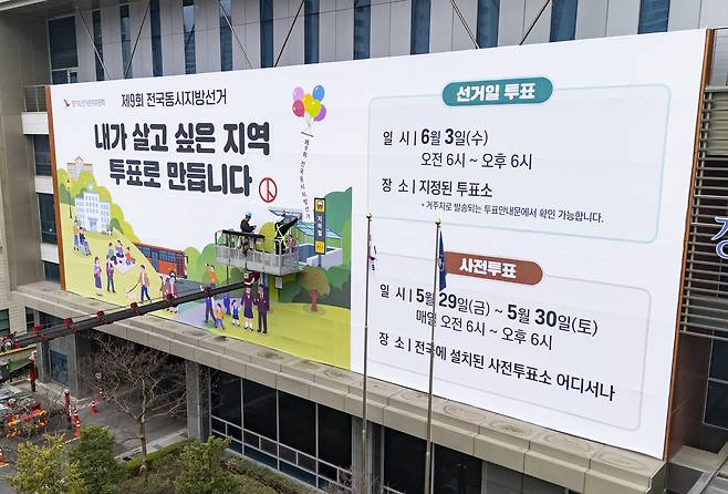 제9회 전국동시지방선거를 앞두고 경기도 수원시 영통구 경기도선거관리위원회에서  지난달 9일 투표 참여 홍보 현수막을 설치하고 있다. [연합]