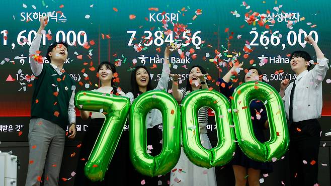 코스피가 7000을 돌파한 6일 서울 중구 하나은행 본점 딜링룸에서 직원들이 축하 세리모니를 하고 있다. 뉴스1