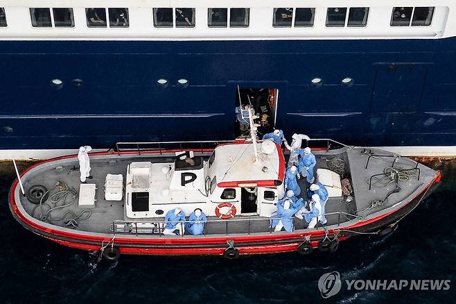 6일 보건의료인들이 크루즈선에서 환자 하선을 돕는 모습 [AFP 연합뉴스. 재판매 및 DB 금지]