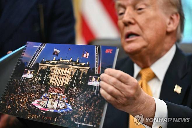 '백악관 UFC 이벤트' 조감도 공개한 트럼프 대통령 (AFP=연합뉴스) 도널드 트럼프 대통령이 6일(현지시간) 백악관 오벌오피스에서 다음달 14일 백악관에서 열릴 이종격투기 이벤트 조감도를 보여주고 있다. 2026.5.6