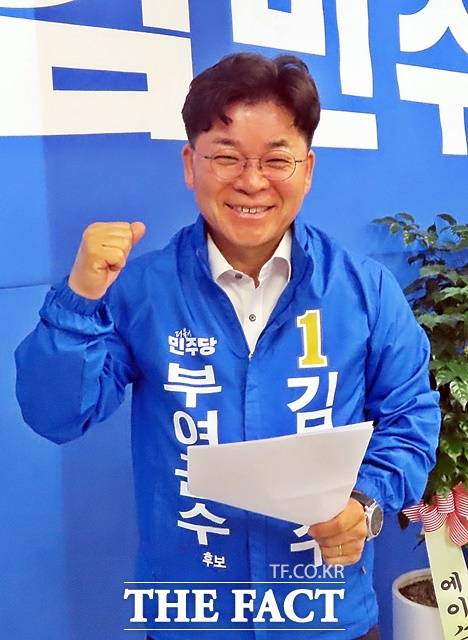 김민수 민주당 부여군수 후보가 자신의 선거사무소에 걸린 대형 현수막앞에서 파이팅을 외치고 있다. /김형중 기자