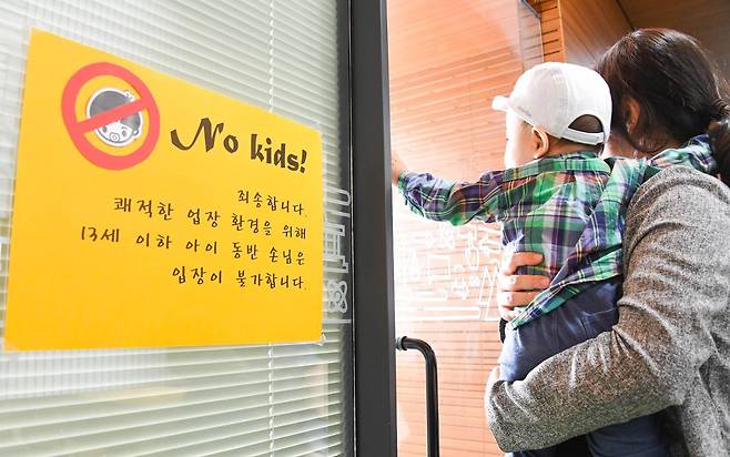 민폐일지도 모르는 아이와 보호자를 미리 추방하는 세계. 아기와 엄마를 가로막는 '노키즈' 문구가 관용 없는 사회를 상징적으로 보여준다. 한국일보 자료사진