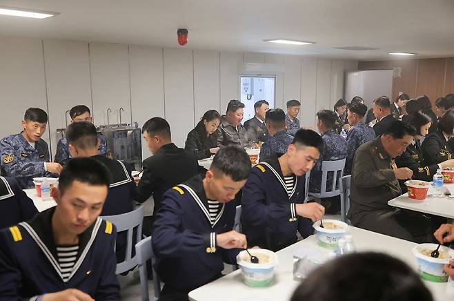 김정은 북한 국무위원장이 지난 7일 최현호에서 딸 주애와 함께 함내 식당에서 즉석밥이 놓인 식탁에서 해병들과 자리를 함께 하는 모습. 노동신문, 뉴스1