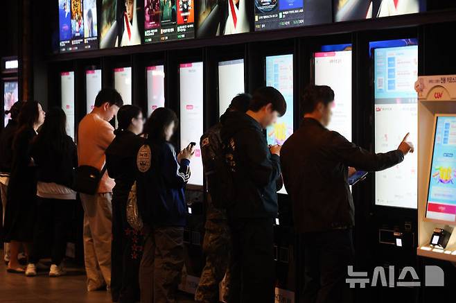 [서울=뉴시스] 권창회 기자 = 12일 서울 시내 영화관에서 시민들이 영화를 보기 위해 상영정보를 살펴보고 있다. 정부가 경기 침체가 예상되는 문화·관광·체육 분야 지원을 위해 약 4,600억원 규모의 예산을 추가로 투입한다. 그 중 전국 영화관 관람료 할인을 위한 예산으로 271억원을 편성해 1매당 6천원이 할인되는 티켓이 총 450만장 배포된다. 2026.04.12. kch0523@newsis.com