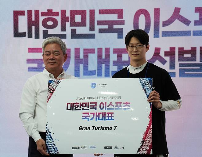 그란투리스모7 아시안게임 국가대표 선발된 김영찬 선수 (용인=연합뉴스) 김주환 기자 = 8일 경기 용인시 AMG 에버랜드 스피드웨이에서 열린 2026 아이치·나고야 아시안게임 e스포츠 '그란투리스모 7' 국가대표 선발전 결선에서 최종 1위를 기록한 김영찬(26·DCT 레이싱) 선수가 기념사진을 촬영하고 있다. 왼쪽은 신영수 대한자동차경주협회 회장. 2026.5.8 jujuk@yna.co.kr