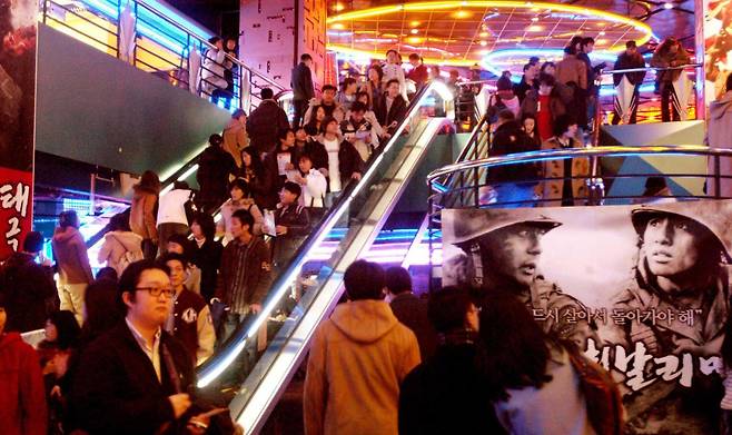 2004년 2월 영화 '태극기가 휘날리며'가 상영 중인 서울 삼성동 메가박스 코엑스몰에 관객들이 영화를 보기 위해 몰려들고 있다. 멀티플렉스 체인 메가박스는 CGV, 롯데시네마와 더불어 단관 위주 한국의 극장 문화를 크게 바꿨다. 한국일보 자료사진