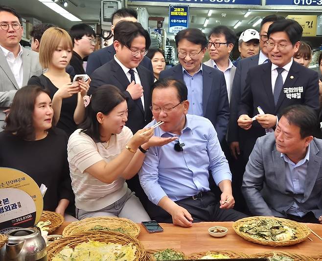 더불어민주당 김부겸 대구시장 후보가 지난 9일 대구 중구 서문시장을 방문해 부침개를 먹으며 시민들과 소통하고 있다. /장은희기자