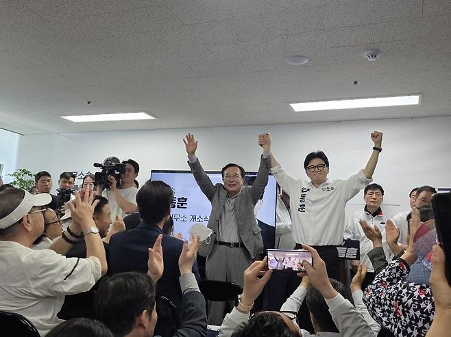 부산 북갑 국회의원 보궐선거에 출마하는 무소속 한동훈 후보가 10일 오후 부산 북구에서 열린 선거사무소 개소식에서 서병수 명예 선대위원장과 손을 잡고 양팔을 들어 올리고 있다.  연합뉴스