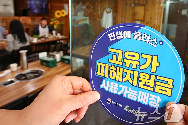고유가 피해지원금 1차 지급이 시작된 27일 대구 수성구 한 음식점에서 상인이 고유가 피해지원금 사용 가능 매장을 알리는 스티커를 붙이고 있다. 2026.4.27 ⓒ 뉴스1 공정식 기자
