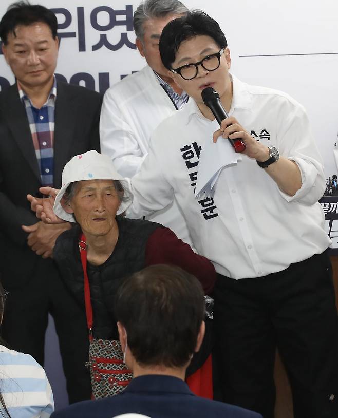 부산 북구갑 국회의원 보궐선거에 출마한 한동훈 무소속 후보가 10일 오후 부산 북구에서 열린 선거사무소 개소식에서 찰밥 할머니를 소개하고 있다. 뉴스1