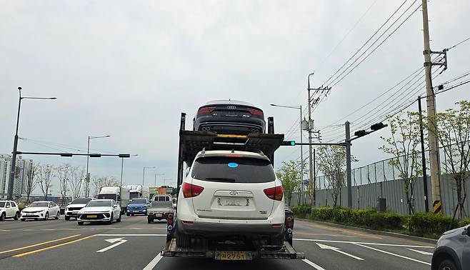 지난달 27일 인천 송도 중고차수출단지 인근에서 트레일러가 중고차를 실어나르고 있다. 인천=고석현 기자