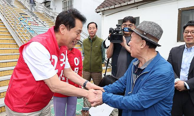오세훈 국민의힘 서울시장 후보가 11일 오후 서울 구로구 고척동 고지대 이동편의시설 설치 대상지를 찾아 주민과 인사하고 있다. 뉴시스