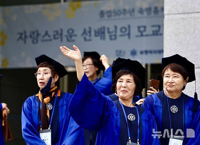 [서울=뉴시스] 김명년 기자 = 12일 오전 서울 용산구 숙명여자대학교 백주년기념관에서 열린 '졸업 50주년 홈커밍데이' 행사에서 학위복을 입은 50여년 전 졸업생이 동문에게 손을 흔들고 있다. 2026.05.12. kmn@newsis.com