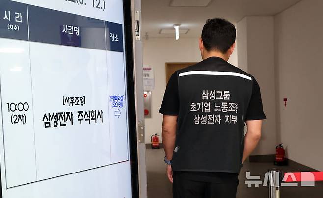 [세종=뉴시스] 강종민 기자 = 삼성전자 노사가 정부세종청사 중앙노동위원회에서 2차 사후조정 회의를 벌인 12일 노측 관계자가 협상장으로 들어가고 있다. 2026.05.12. ppkjm@newsis.com