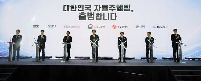 업무협약식에 참석한 주요 인사들이 전자서명판에 서명하기 위해 연단에 서 있다. (왼쪽부터) 한지형 오토노머스 A2Z 대표, 박민우 현대차·기아 AVP본부장 사장, 정용식 한국교통안전공단 이사장, 김윤덕 국토교통부 장관, 강기정 광주광역시 시장, 이문화 삼성화재 사장, 박중희 라이드플럭스 대표. ⓒ현대차·기아