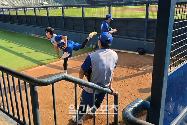 12일 서울 잠실야구장에서 쉐도우 피칭하는 원태인(왼쪽)과 불펜 피칭하는 양창섭(오른쪽), 그리고 이를 지켜보며 피드백을 하는 이승민(28번). 잠실=윤승재 기자