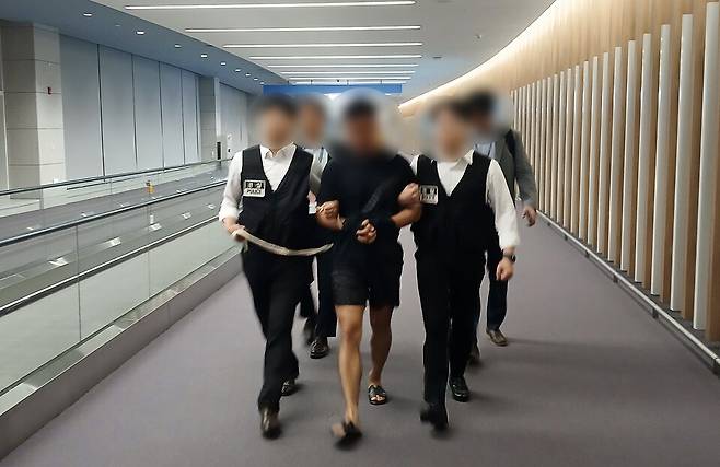 법무부 관계자들이 그룹 방탄소년단(BTS) 정국을 포함한 국내 재력가들의 명의를 도용해 거액을 빼돌린 해킹조직 총책을 2025년 8월22일 오전 인천국제공항을 통해 강제송환하고 있다. ⓒ법무부 제공