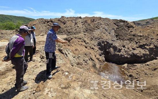 ▲ 13일 울산 울주군 두서면 내와리 주민들이 외와저수지 인근 불법 성토 신고 현장에서 흘러나온 붉은 빛깔의 침출수를 가리키고 있다.